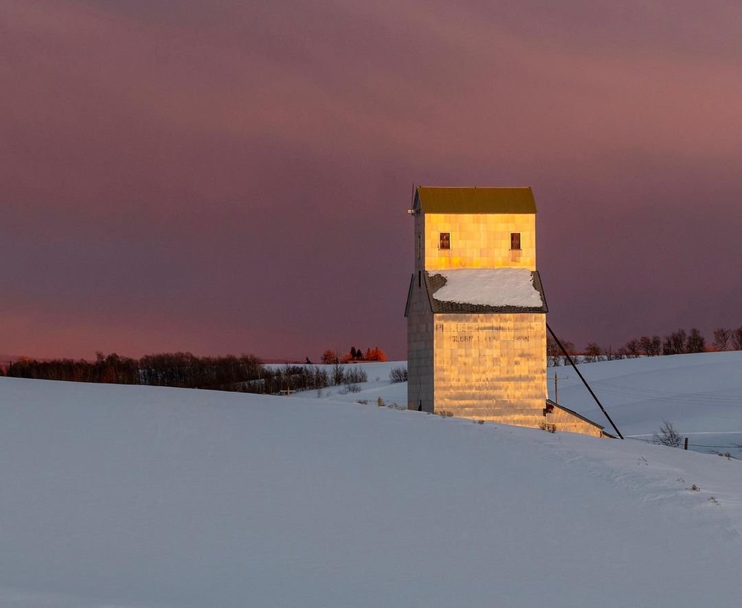 Antique Pillsbury grains elevator in Eastern Idaho, photographed last winter. Setting sun cast golden light on the corrugated panel facade, creating a lantern on the open western landscape. This image was a hit at our recent exhibit at Cove Street Arts in Portland, Maine. #grainelevator #idahophotography #orcuttphotography #pillsburyelevator #westernphotography