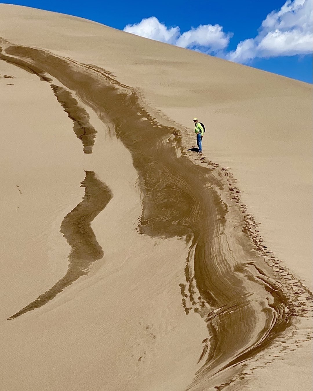 Cindy Orcutt making her way up the last ridge to one of the highest dunes in Sand Dunes National Park today. The scale of this extraordinary landscape is overwhelming. Great place for photography. #greatsanddunesnationalpark #orcuttphotography.danstpeter.com #climbingthedunes
