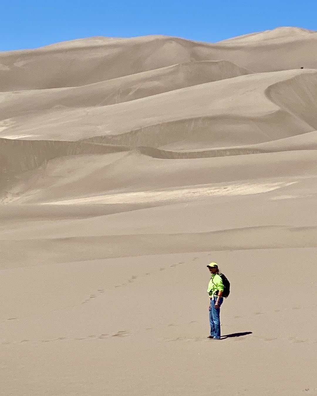 Cindy Orcutt preparing to climb the dunes at Sand Dune National Park in southern Colorado. Hiking there is fairly strenuous due to steep pitches and soft sand. Each step forward is accompanied with a half step sliding backward. #greatsanddunesnatuonalpark #orcuttphotography.danstpeter.com #hikingthedunes #revelvantookusthere