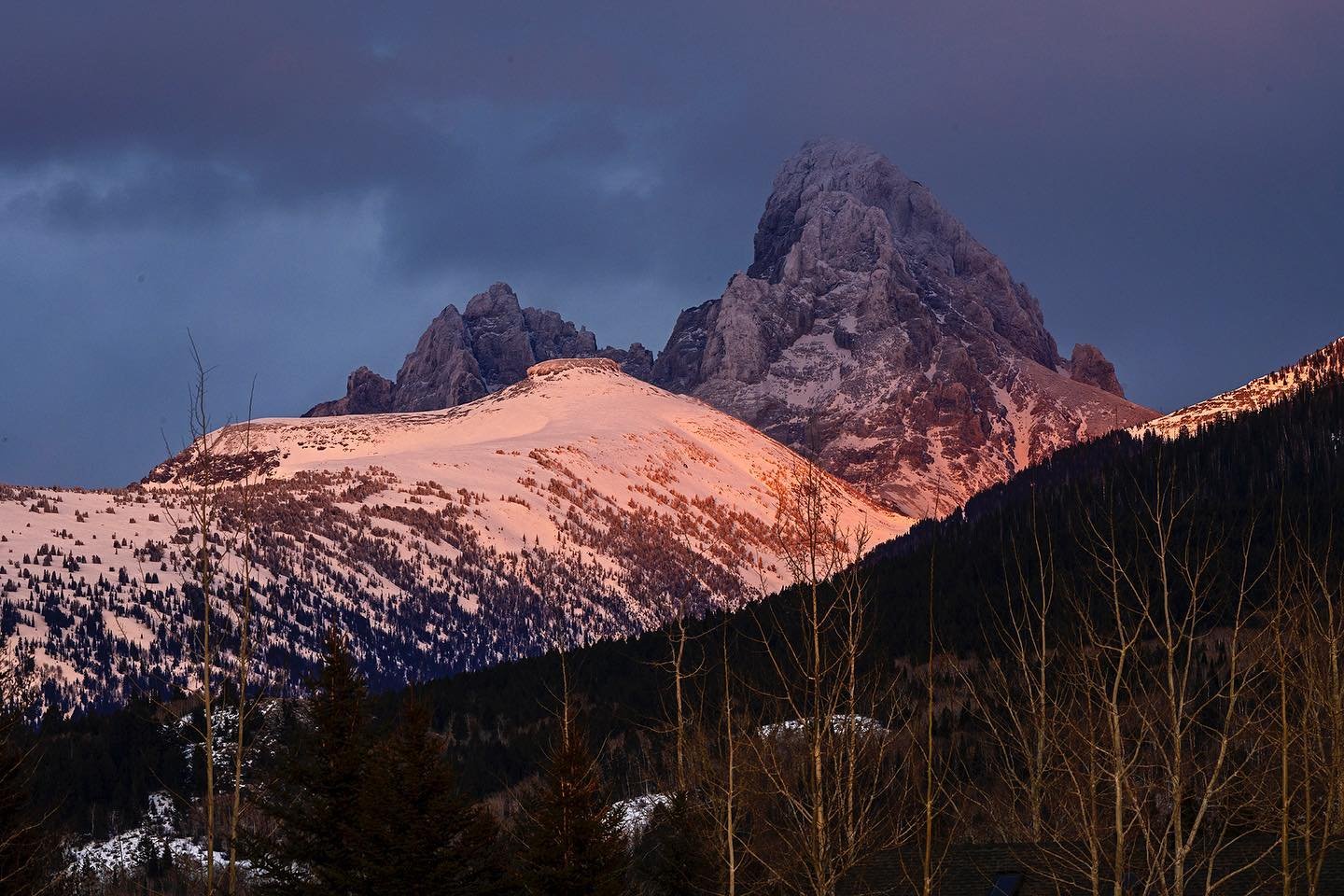 Table Mountain is illuminated by the setting sun across Teton Valley with the Grand Teton behind it. This view from our backyard in Driggs, Idaho is a constantly changing scene and never seems the same! #tablemountain #tetonvalleyidaho #bestofthegemstate #orcuttpgotography