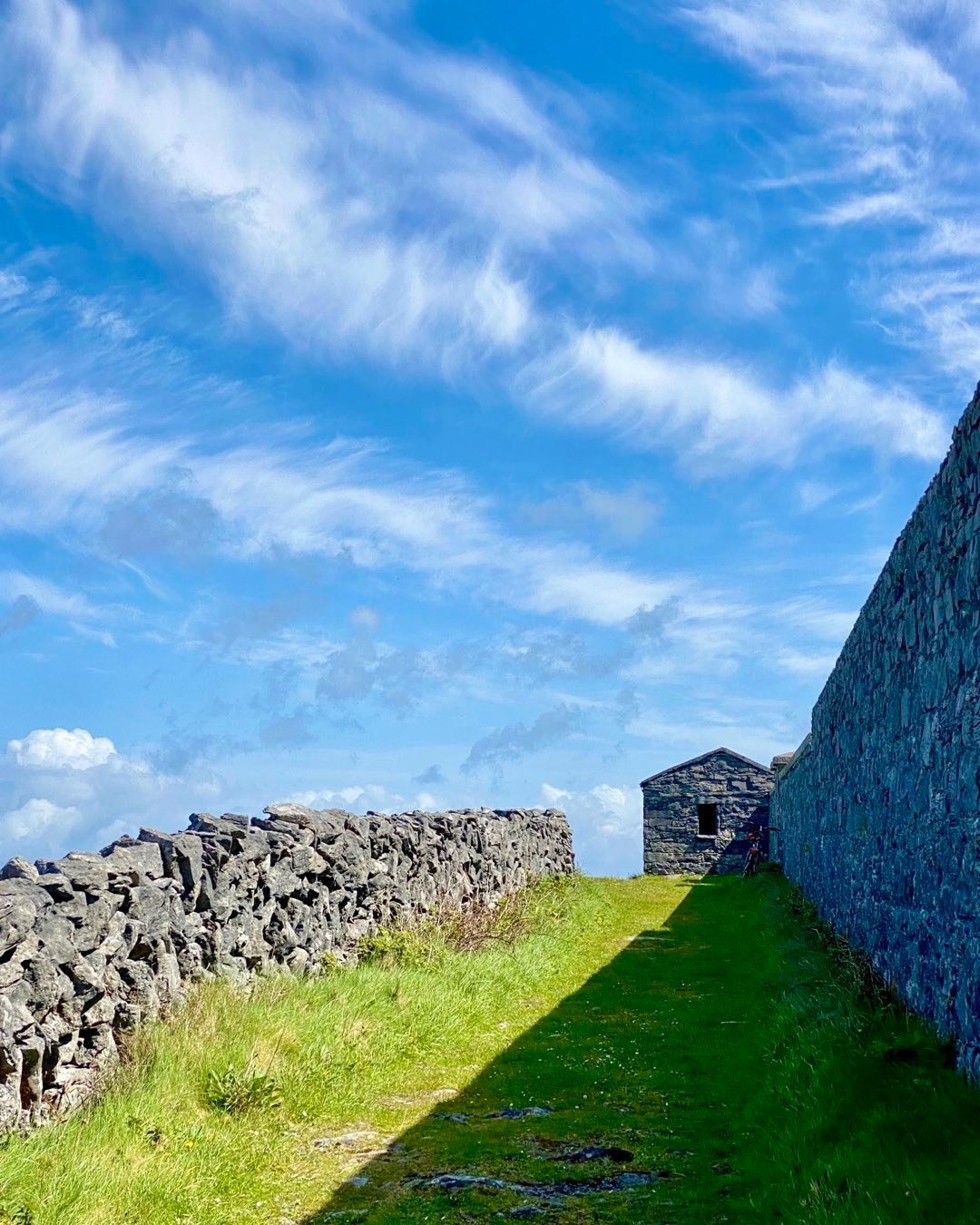 Stone walls and buildings on the bright green landscape are everywhere in Western Ireland. This strong composition by Cindy Orcutt clearly expresses these iconic elements on Inis Mor in the Aran Islands. #ireland #inismoraranislands #westernireland #stonewalls #orcuttphotography